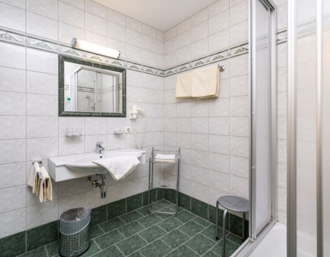 Badezimmer mit Dusche, Waschbecken und Handtuchw&auml;rmer