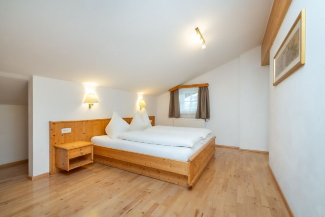 Schlafzimmer mit Doppelbett und Mansarde